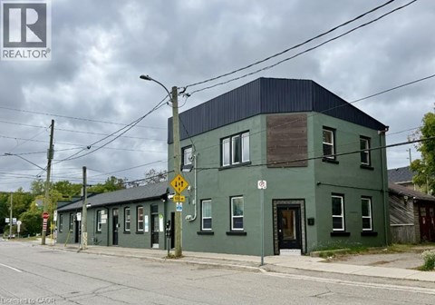 A green building with a black roof and a no parking sign in front of it.