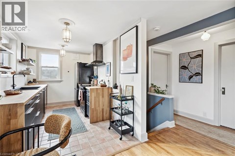 A kitchen with a black refrigerator and a wooden island.