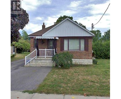 A house with a porch and a sign that says RE/MAX Rouge River Realty LTD. Brokerage.