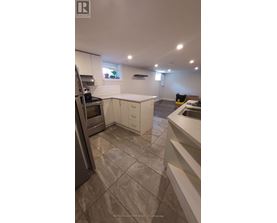 A kitchen with a tile floor and white cabinets.
