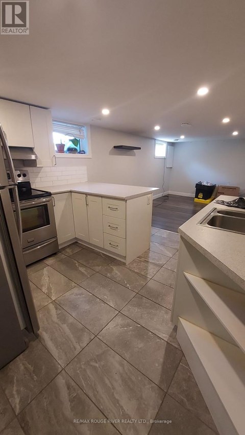 A kitchen with a tile floor and white cabinets.