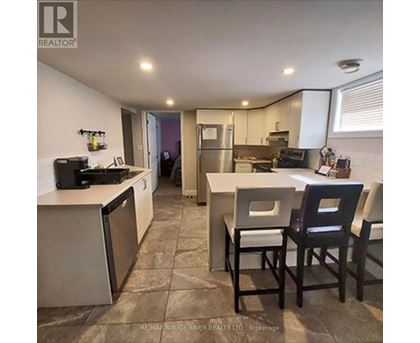A kitchen with a refrigerator, dishwasher, and a sink.