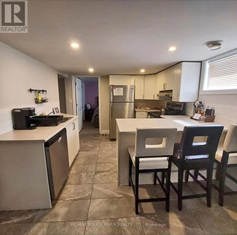 A kitchen with a refrigerator, dishwasher, and a sink.