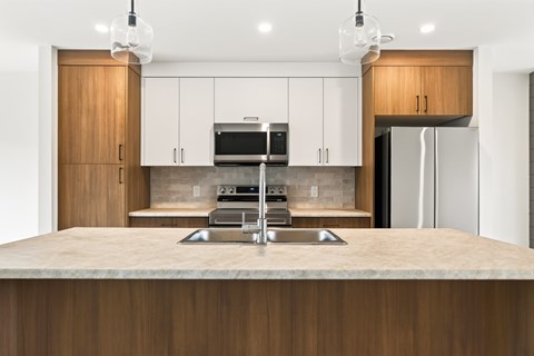 A modern kitchen with wooden cabinets and a central island.