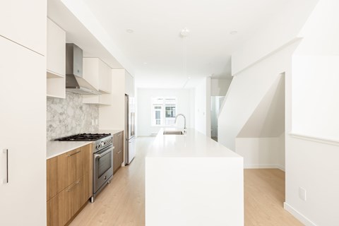 A modern kitchen with wooden cabinets and a white countertop.