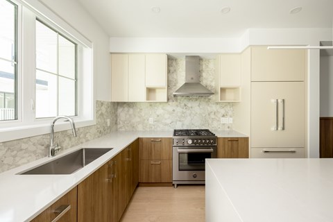 A modern kitchen with wooden cabinets and stainless steel appliances.