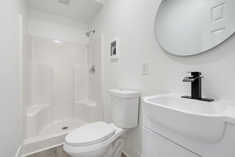 A white toilet sits next to a white sink in a small bathroom.