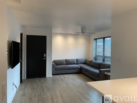 A living room with a grey couch and a black door.