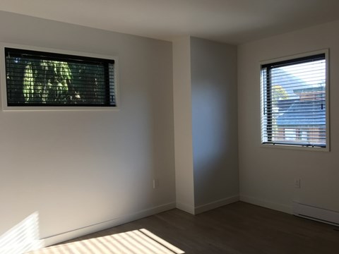A room with a window and a picture on the wall.