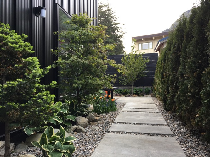 A garden pathway with a black building in the background.