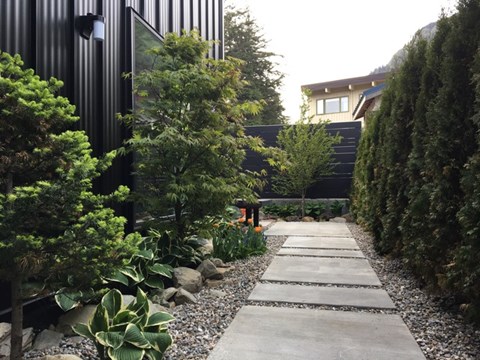 A garden pathway with a black building in the background.
