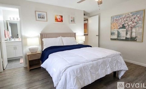 A bedroom with a large bed and a ceiling fan.