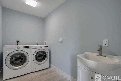 A laundry room with a washer and dryer and a sink.