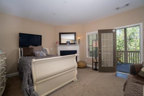 A bedroom with a large bed and a flat screen TV.