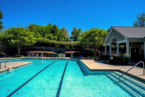 A large swimming pool with a building in the background.