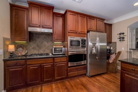 A kitchen with wooden cabinets and a stainless steel refrigerator.