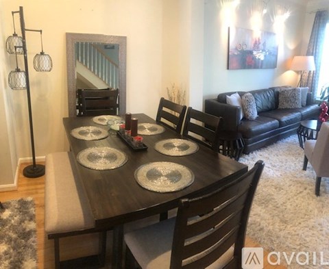 A dining room with a wooden table and chairs.