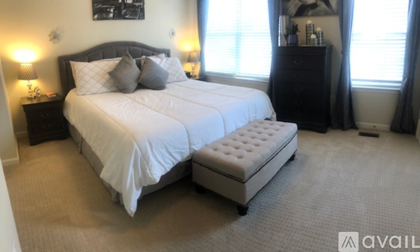A bedroom with a large bed and a bench in front of it.