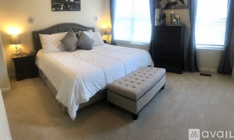 A bedroom with a large bed and a bench in front of it.