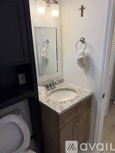 A bathroom with a sink, mirror, and towel rack.
