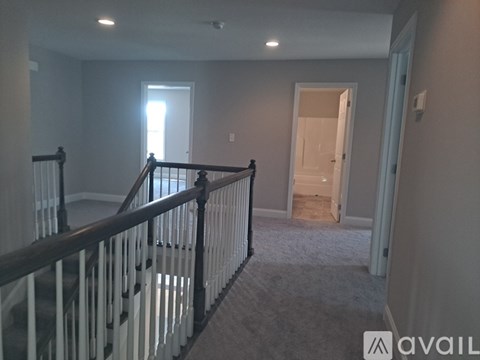 A spacious room with a staircase leading to the second floor.