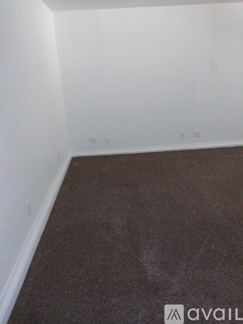 A room with white walls and brown carpet.