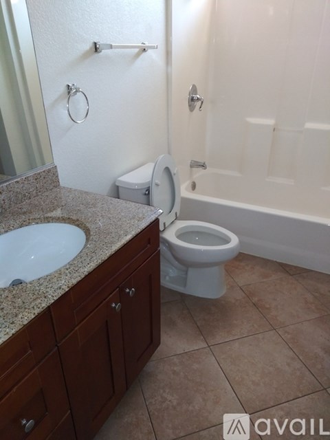 A bathroom with a toilet, sink, and bathtub.
