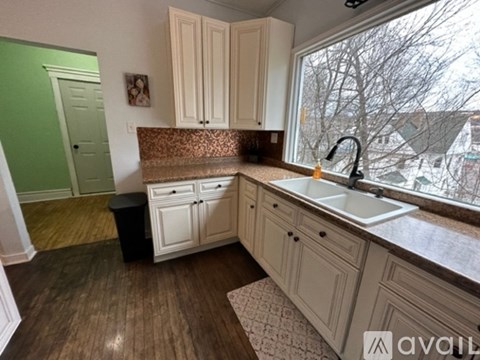 A kitchen with white cabinets and a brown countertop.