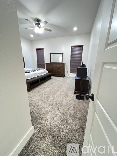 A bedroom with a bed, dresser, and mirror.