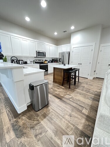 A kitchen with white cabinets and a wooden island.
