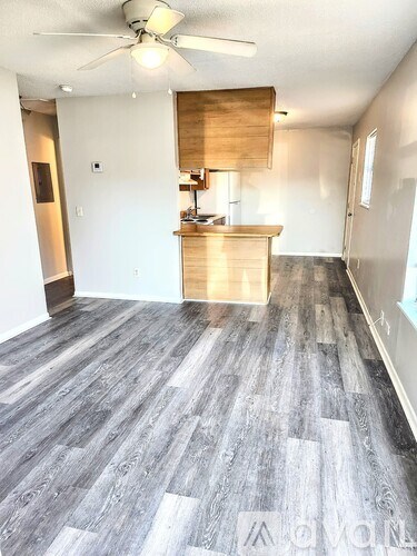 A room with a wooden floor and a ceiling fan.