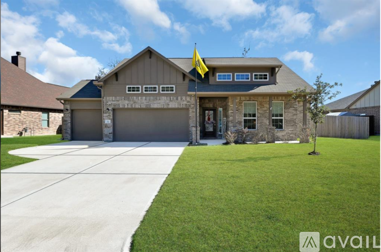 A house with a flag on the roof and a driveway in front.