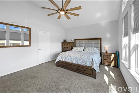A bedroom with a bed, dresser, and ceiling fan.