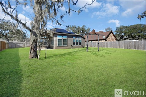 A house with a large lawn and a tree in front of it.