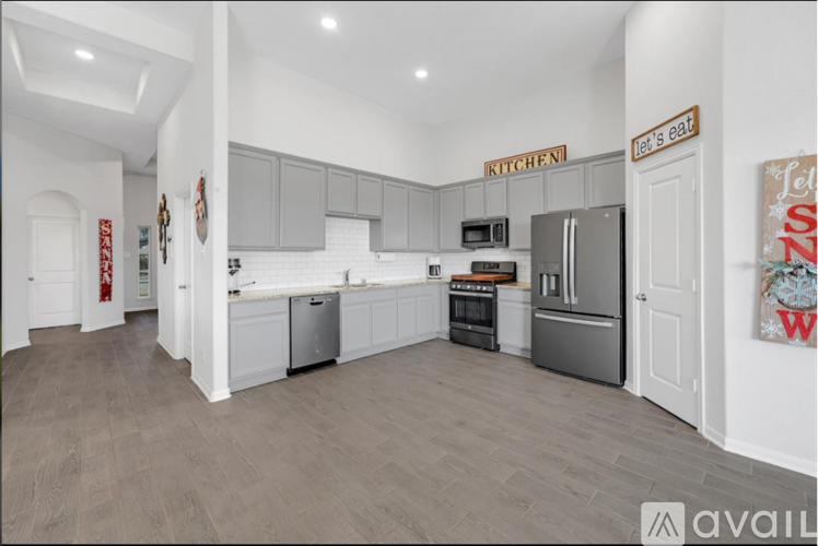 A kitchen with a refrigerator, oven, and microwave.