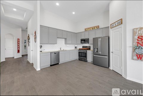 A kitchen with a refrigerator, oven, and microwave.