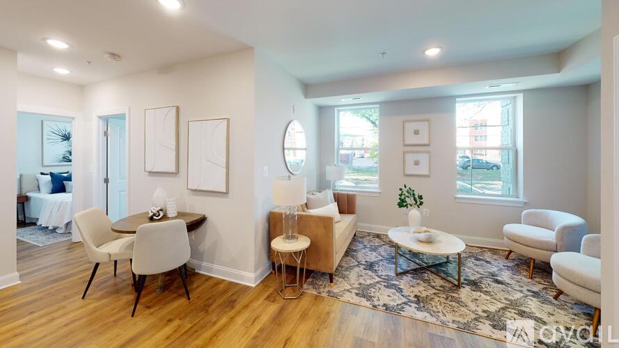 A living room with a white couch, a wooden table, and a rug.