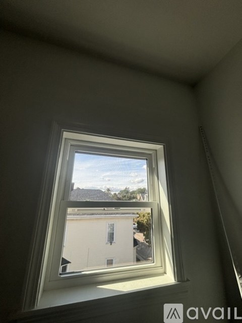 A window with a view of a building and trees outside.