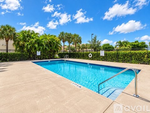 A swimming pool surrounded by a fence and trees.