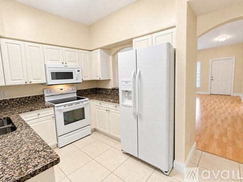 A kitchen with a granite counter top and white appliances.