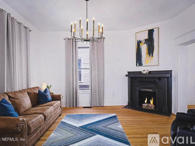 A living room with a fireplace and a brown couch.