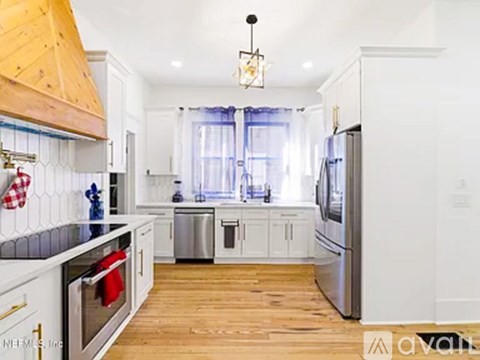 A kitchen with wooden cabinets and a stainless steel refrigerator.