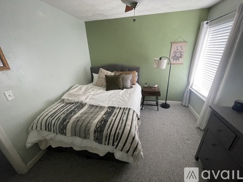A bedroom with a bed, nightstand, and lamp.