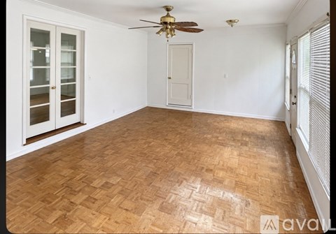 A room with wooden flooring and a ceiling fan.