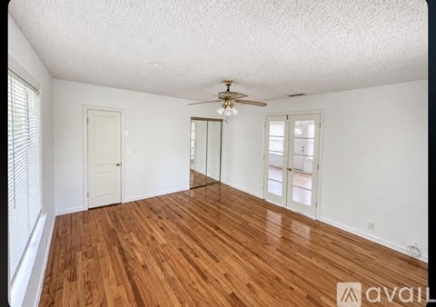 A room with wooden floors and a ceiling fan.