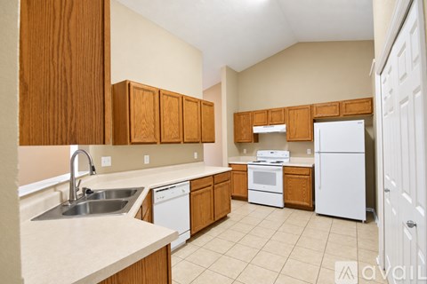 A kitchen with wooden cabinets and white appliances.