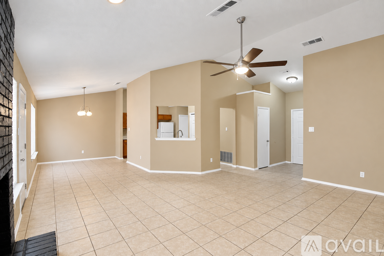 A spacious room with a ceiling fan and tiled flooring.