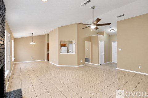 A spacious room with a ceiling fan and tiled flooring.