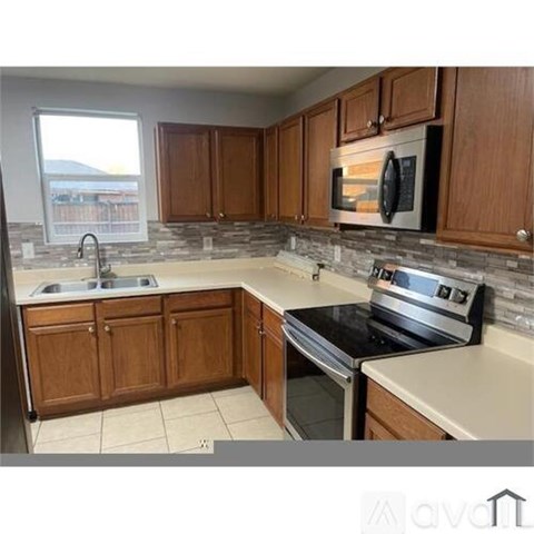 A kitchen with wooden cabinets and a stove top oven.