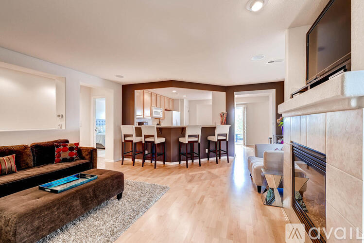 A modern living room with a brown couch and a wooden floor.